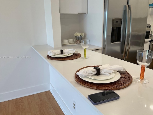 kitchen featuring white cabinetry, hardwood / wood-style floors, and stainless steel fridge with ice dispenser