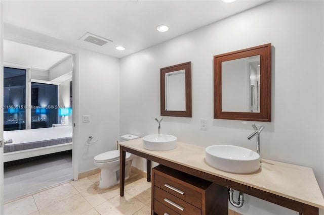 bathroom with tile patterned flooring, vanity, and toilet