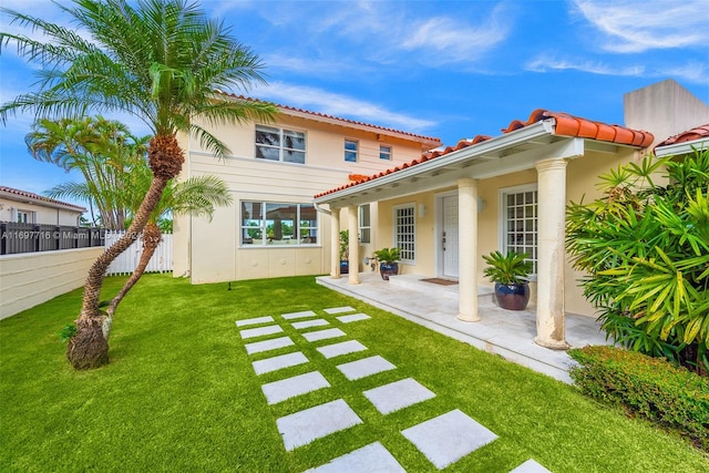 rear view of property featuring a lawn