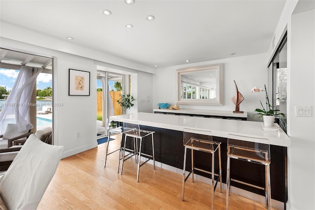 kitchen featuring plenty of natural light, a kitchen breakfast bar, and light hardwood / wood-style flooring