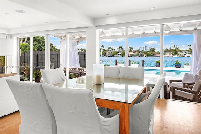 sunroom featuring a wealth of natural light, a water view, and ceiling fan