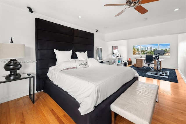 bedroom featuring hardwood / wood-style flooring, ceiling fan, and ornamental molding