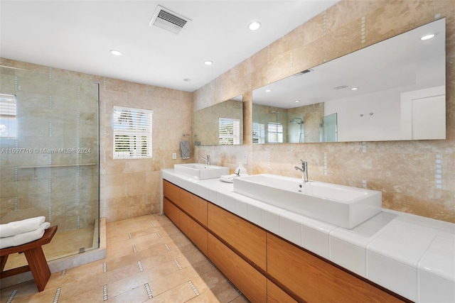 bathroom featuring tile patterned flooring, vanity, a tile shower, and tile walls