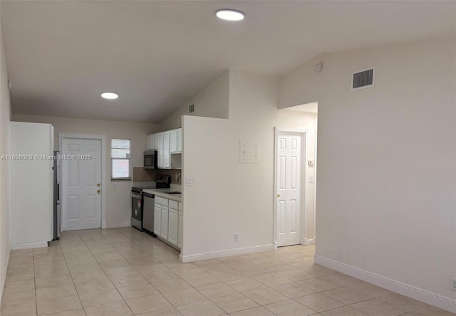 kitchen with vaulted ceiling, stainless steel appliances, and white cabinets