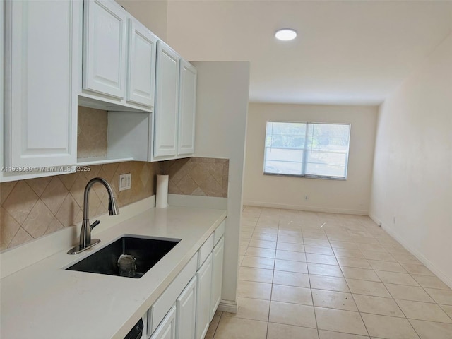 kitchen with white cabinetry, sink, decorative backsplash, and light tile patterned flooring