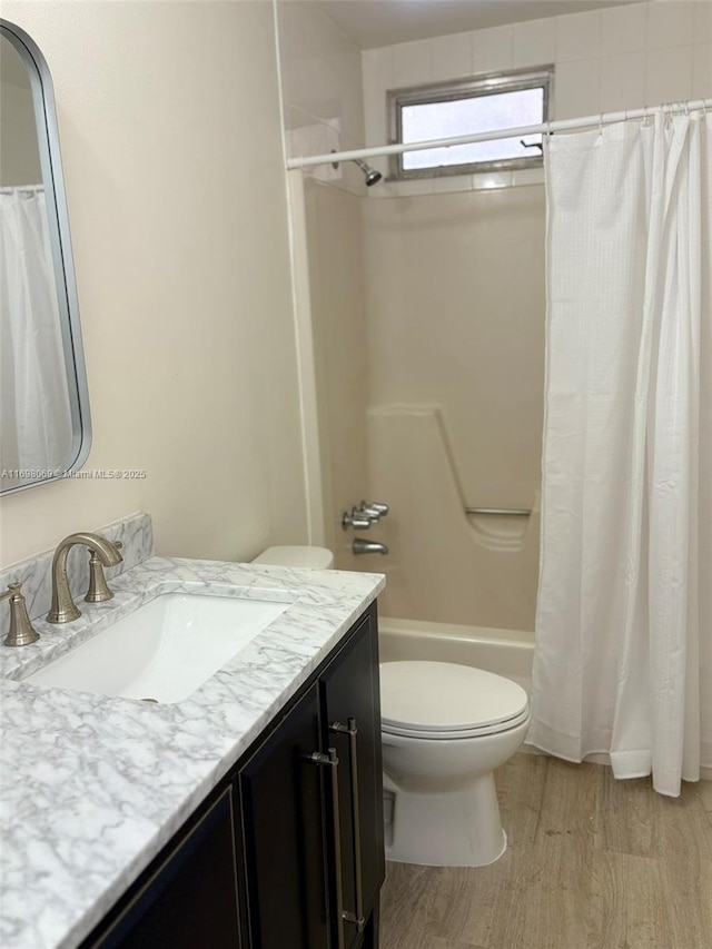 full bathroom with vanity, wood-type flooring, shower / bath combo, and toilet