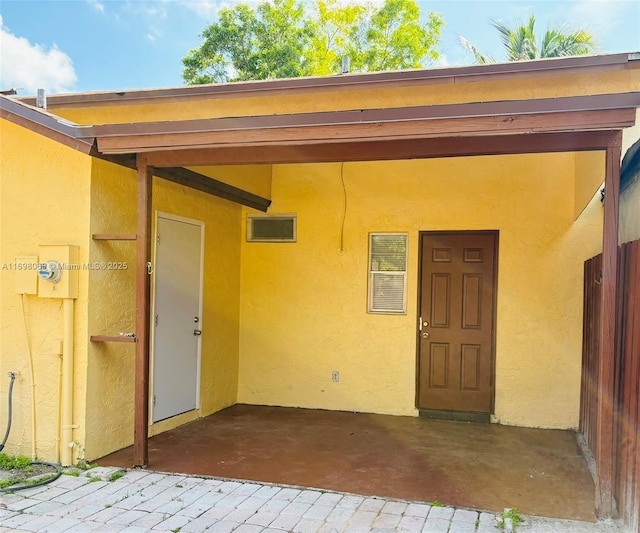 view of exterior entry featuring a patio