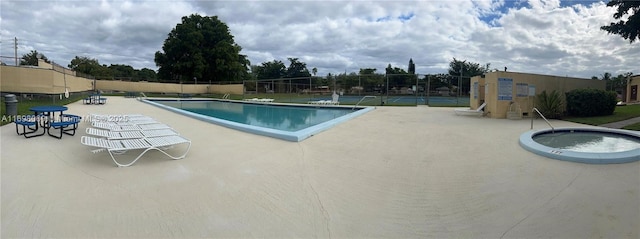 view of swimming pool featuring tennis court