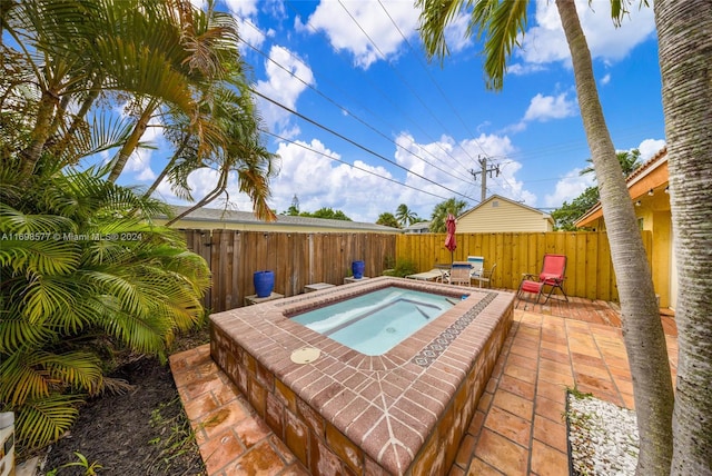 view of pool featuring a patio area and an in ground hot tub