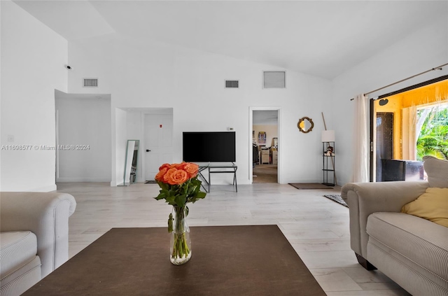 living room featuring light hardwood / wood-style floors and high vaulted ceiling