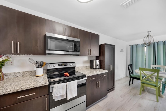 kitchen featuring light stone countertops, a notable chandelier, light hardwood / wood-style floors, dark brown cabinetry, and stainless steel appliances