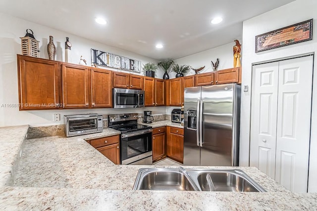 kitchen with light stone countertops, sink, and stainless steel appliances