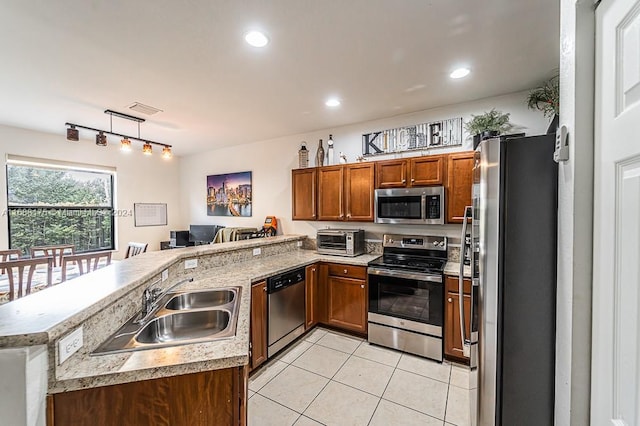 kitchen with kitchen peninsula, light tile patterned floors, stainless steel appliances, and sink