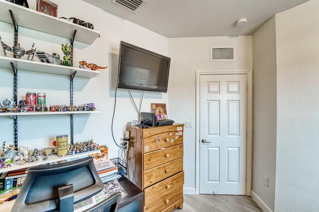 office area featuring light hardwood / wood-style flooring and a textured ceiling