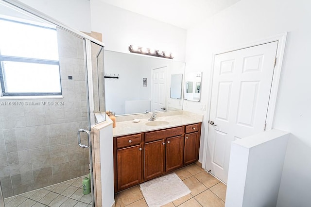 bathroom featuring tile patterned flooring, vanity, an enclosed shower, and a wealth of natural light