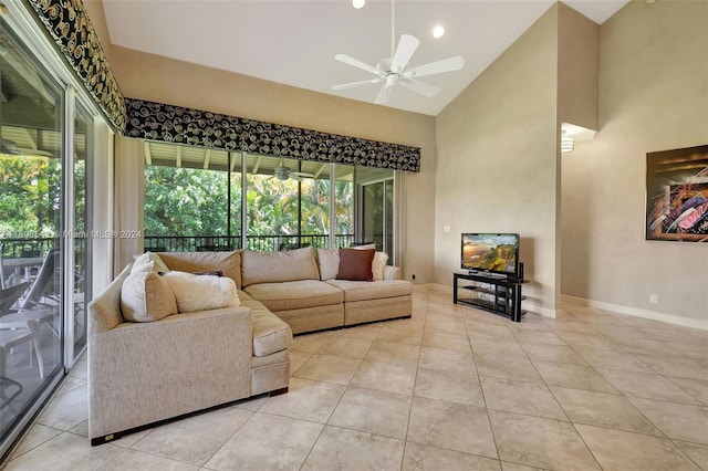 living room with a wealth of natural light, ceiling fan, light tile patterned floors, and high vaulted ceiling