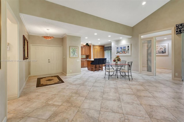 dining room with french doors, lofted ceiling, crown molding, and light tile patterned flooring