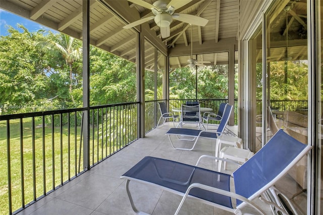 unfurnished sunroom featuring lofted ceiling with beams and ceiling fan