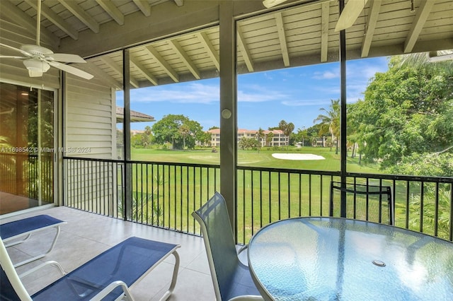 unfurnished sunroom with vaulted ceiling with beams and ceiling fan