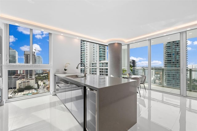 kitchen featuring expansive windows, light tile patterned floors, sink, and beverage cooler