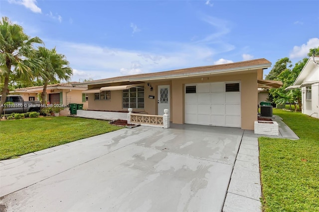 single story home with a front yard, central AC, and a garage