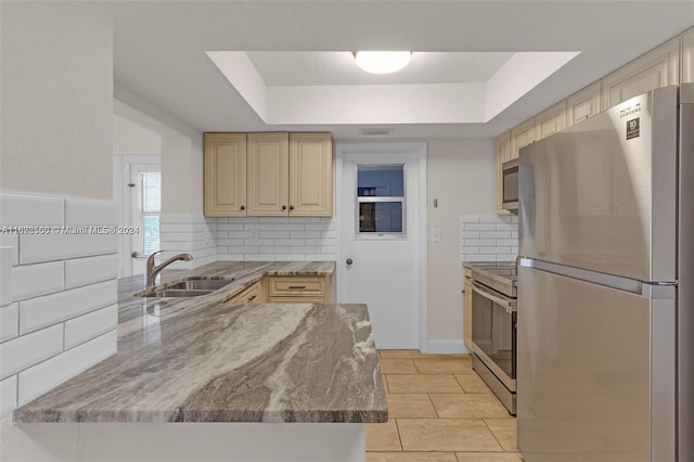 kitchen with decorative backsplash, a raised ceiling, sink, and appliances with stainless steel finishes