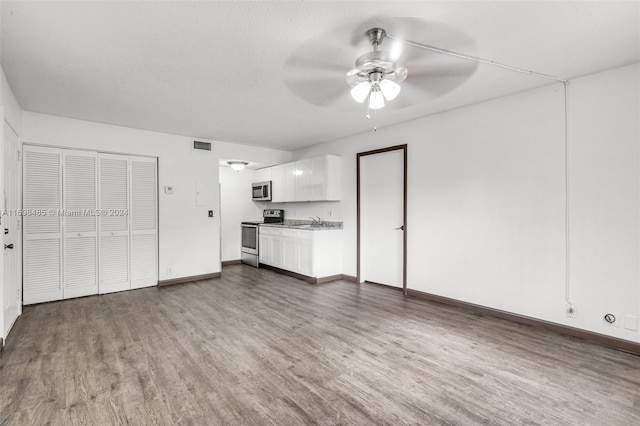 unfurnished living room with a textured ceiling, dark hardwood / wood-style floors, ceiling fan, and sink