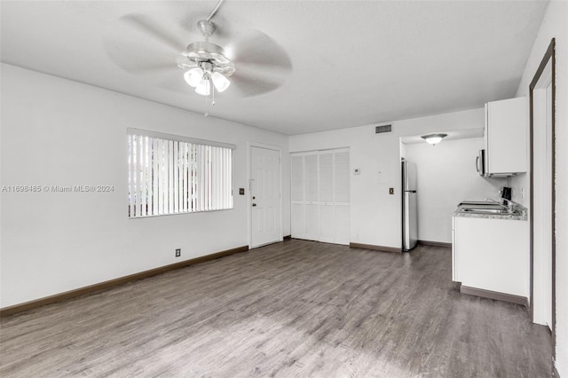 unfurnished living room featuring wood-type flooring and ceiling fan