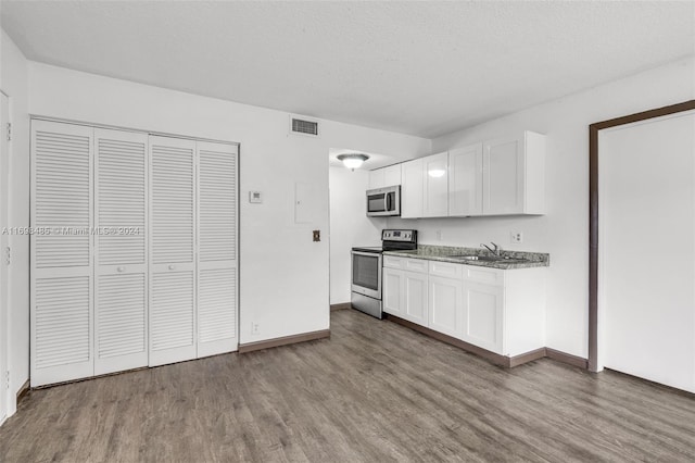 kitchen featuring white cabinets, wood-type flooring, stainless steel appliances, and sink