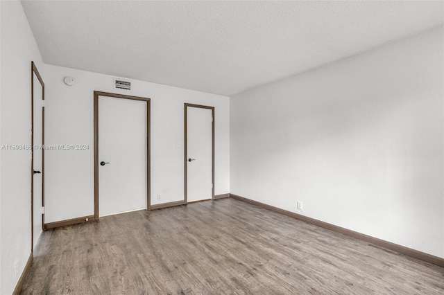 unfurnished bedroom with light hardwood / wood-style flooring and a textured ceiling