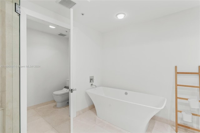 bathroom featuring tile patterned floors, a bathtub, and toilet