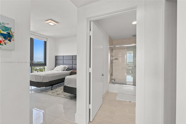 bedroom featuring light tile patterned flooring and ensuite bath