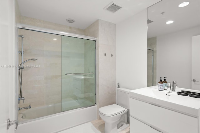 full bathroom with vanity, toilet, and enclosed tub / shower combo