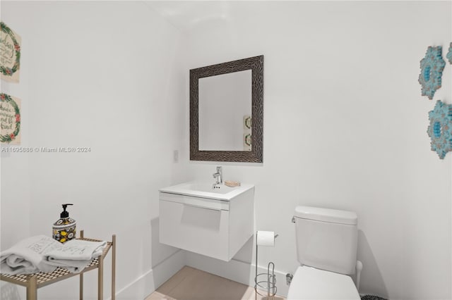 bathroom featuring tile patterned flooring, vanity, and toilet