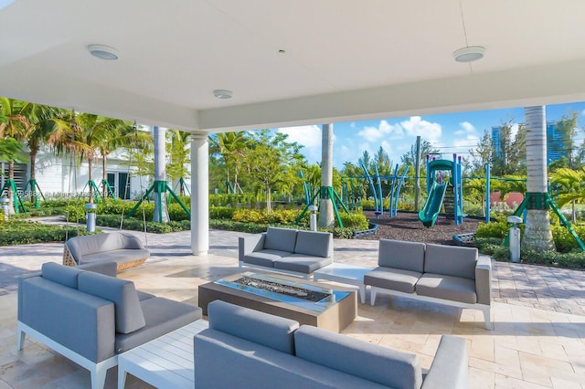 view of patio featuring a playground and an outdoor living space with a fire pit