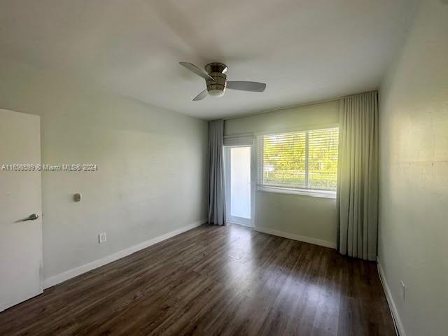 spare room featuring ceiling fan and dark hardwood / wood-style flooring