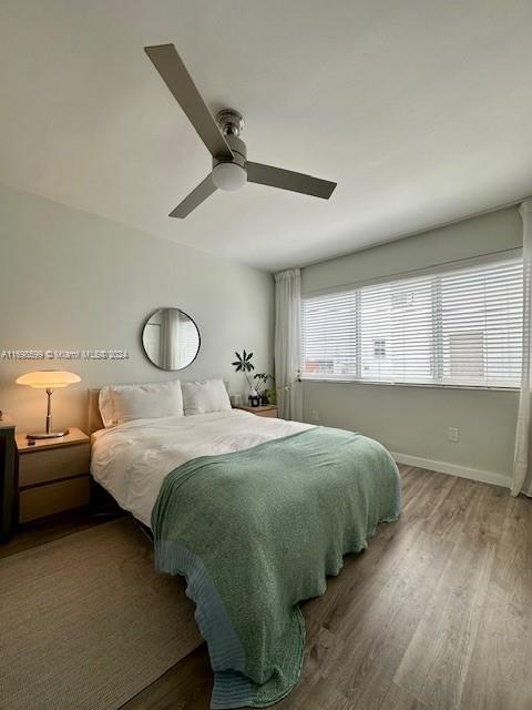 1065 98th St Unit 2, Bay Harbor Islands, FL 33154 - bedroom with wood finished floors, a ceiling fan, and baseboards