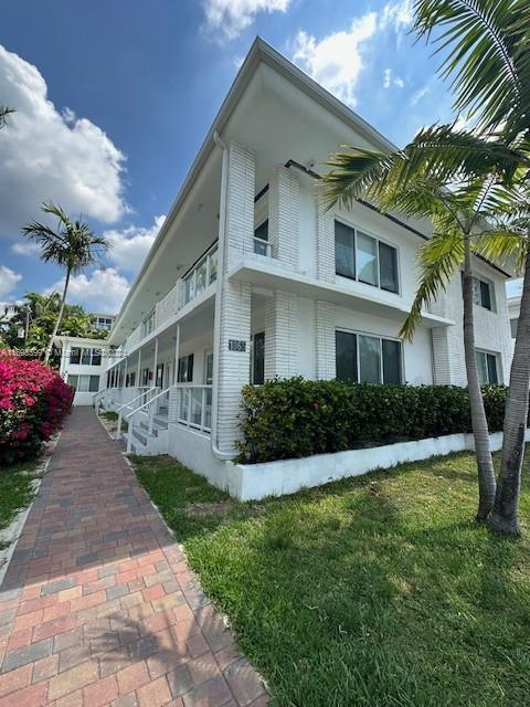 1065 98th St Unit 2, Bay Harbor Islands, FL 33154 - view of side of property featuring a lawn and a porch