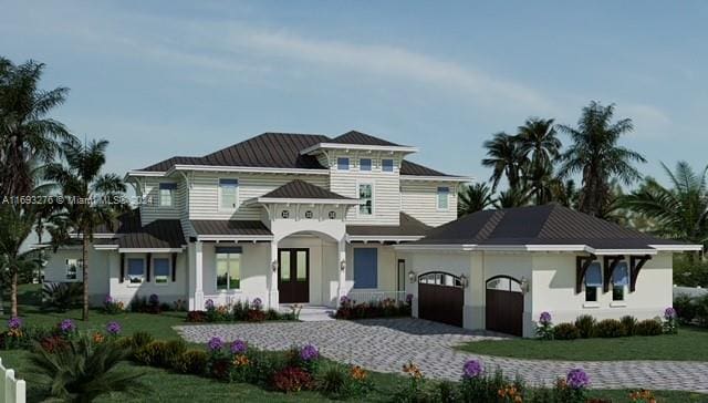 view of front of house featuring a garage, french doors, and a front lawn