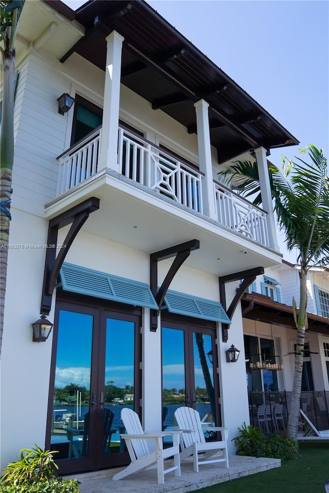 rear view of house with a balcony and french doors