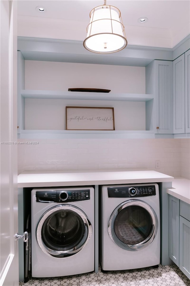 washroom featuring washer and clothes dryer and cabinets