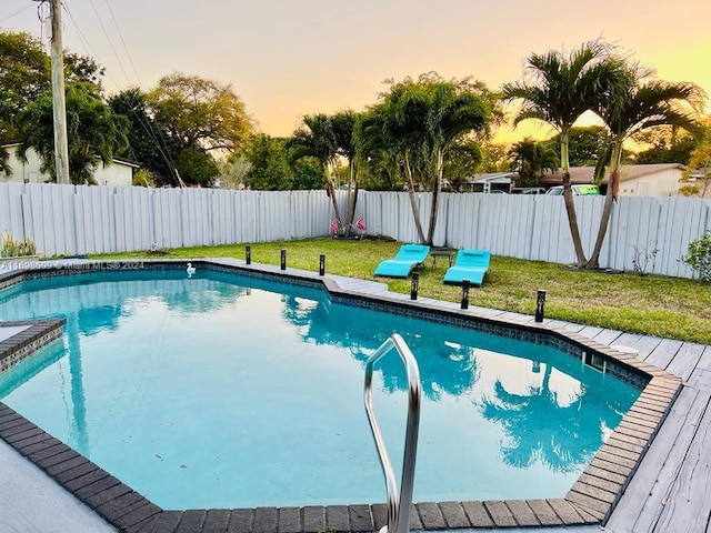 pool at dusk featuring a yard