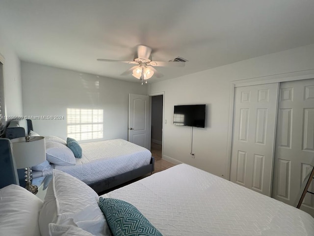 bedroom with hardwood / wood-style flooring, ceiling fan, and a closet