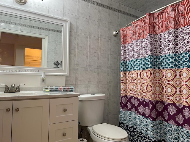 bathroom featuring vanity, toilet, and tile walls