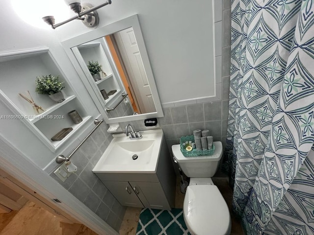 bathroom with a shower with shower curtain, vanity, toilet, and tile walls