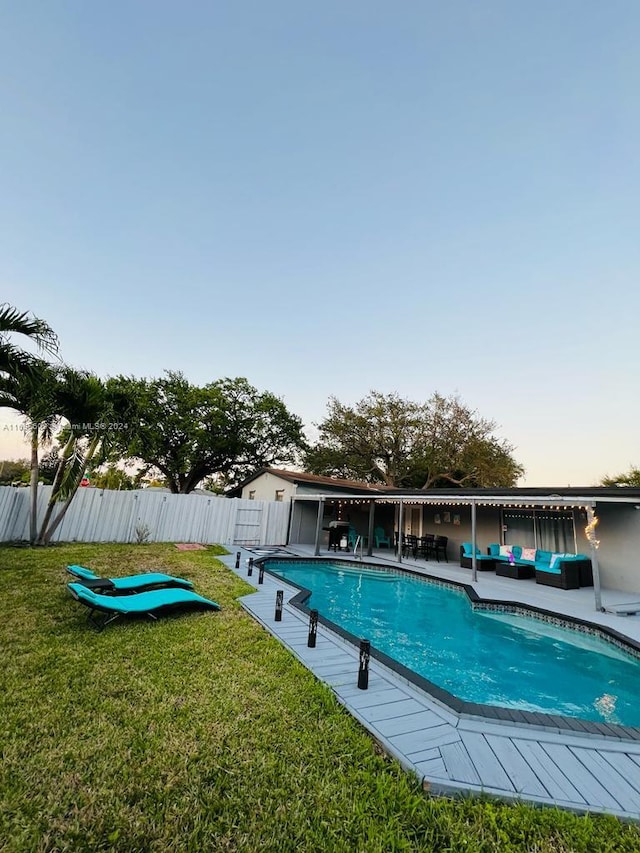 view of swimming pool featuring outdoor lounge area and a lawn