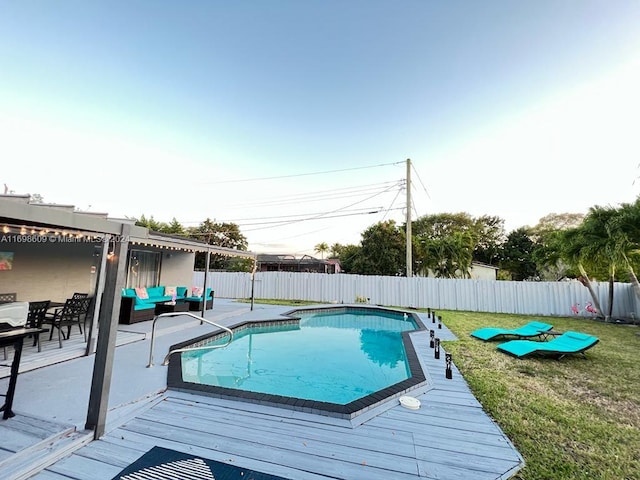 view of swimming pool with a lawn, outdoor lounge area, and a deck