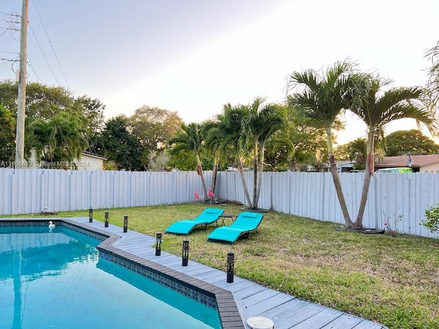 view of pool with a yard