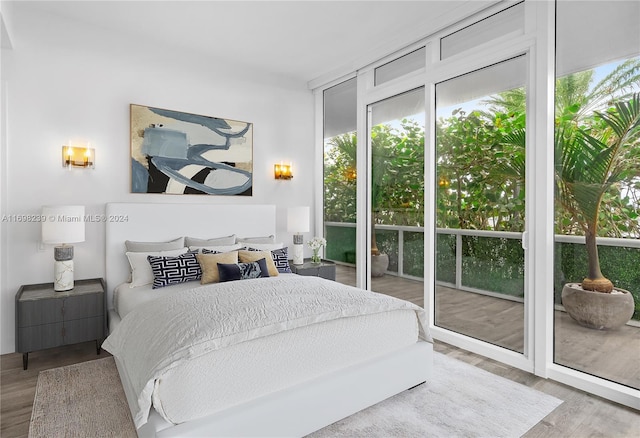 bedroom with access to outside and light wood-type flooring