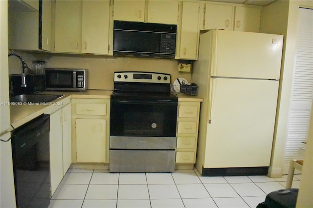 kitchen featuring cream cabinets, sink, light tile patterned floors, and black appliances